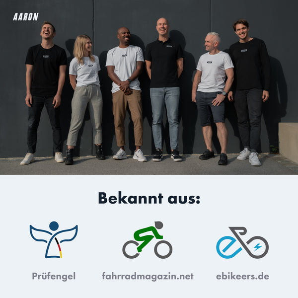 Sechs Personen stehen vor grauer Wand, tragen AARON Urban 3.0 Fahrradpedale - Schwarz auf schwarzer Kleidung sichtbar.