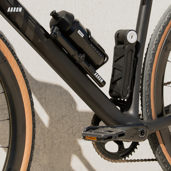 AARON Urban 3.0 Fahrradpedale - Schwarz am Fahrradrahmen mit logo-beschrifteter Trinkflasche im Hintergrund