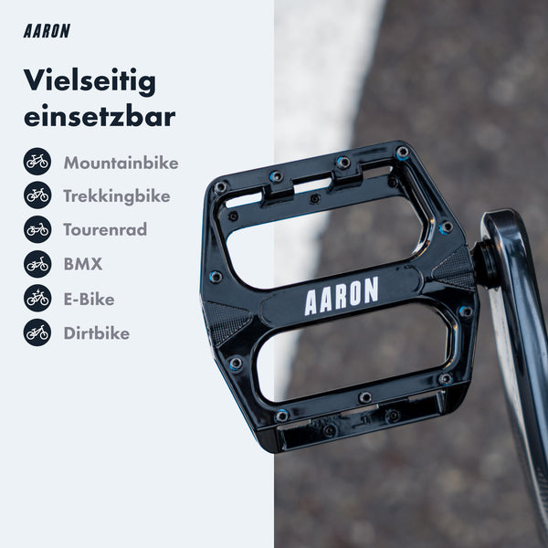 AARON Rock MTB Pedale - Schwarz in Nahaufnahme mit sichtbarem Logo auf schwarzer Plattform vor unscharfem Hintergrund