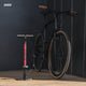 AARON Sport One 3.0 Fahrradpumpe - Rot stehend neben schwarzem Fahrrad mit braunen Griffen vor dunklem Hintergrund